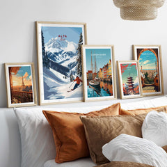Collection of framed travel posters including an Alta Utah ski scene and cityscapes on a sofa backdrop.