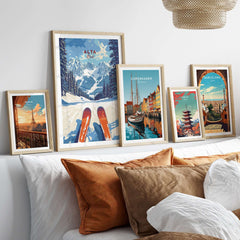 Gallery of framed travel prints including Alta Utah ski view, Copenhagen, and Barcelona on a cozy couch.