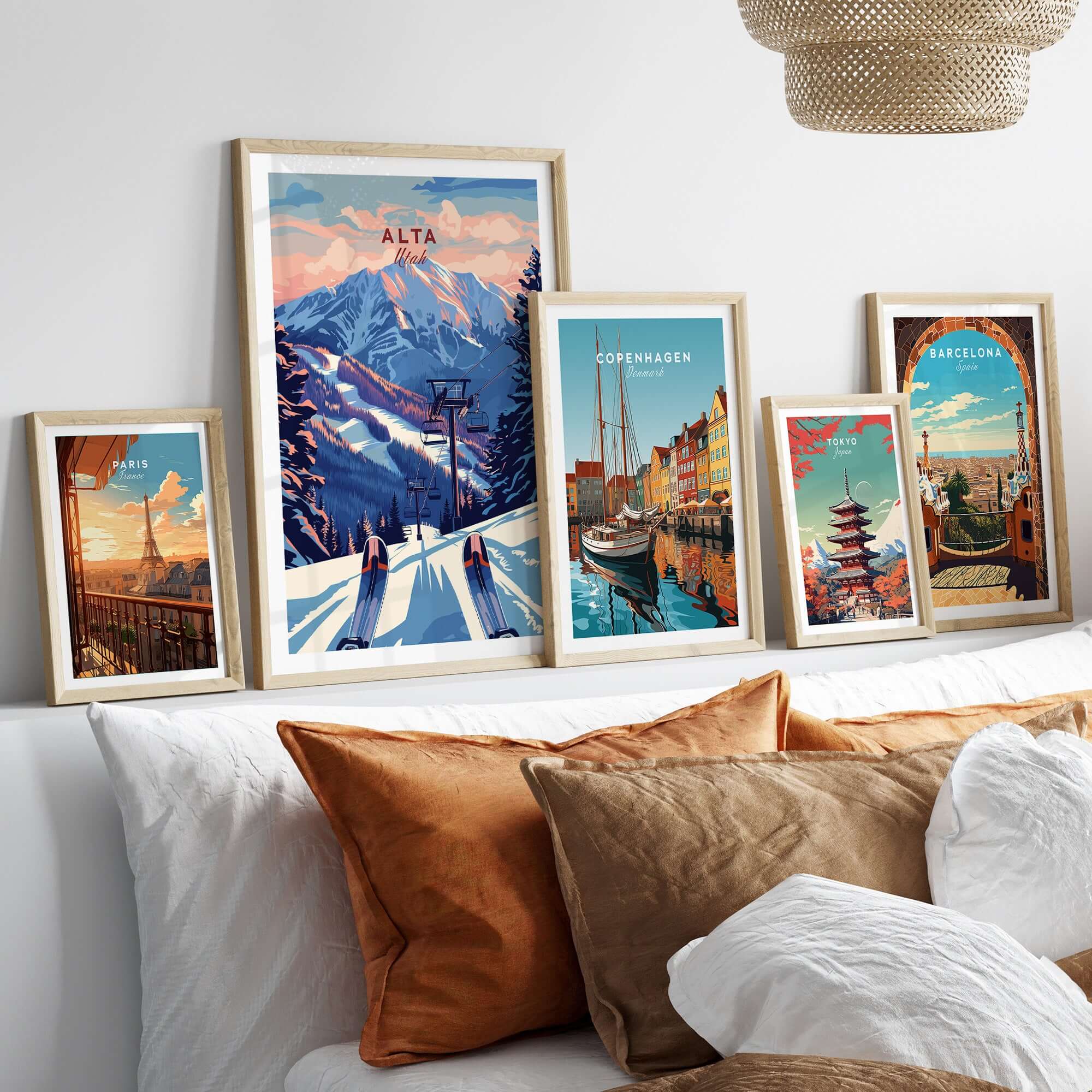 Framed posters of Alta Utah, Copenhagen, and Barcelona on a cozy bed, showcasing travel wall art.