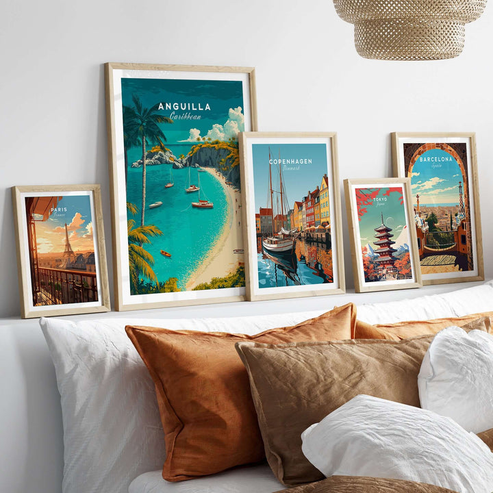 Framed travel posters of Anguilla, Copenhagen, and Barcelona on a cozy couch with decorative pillows.