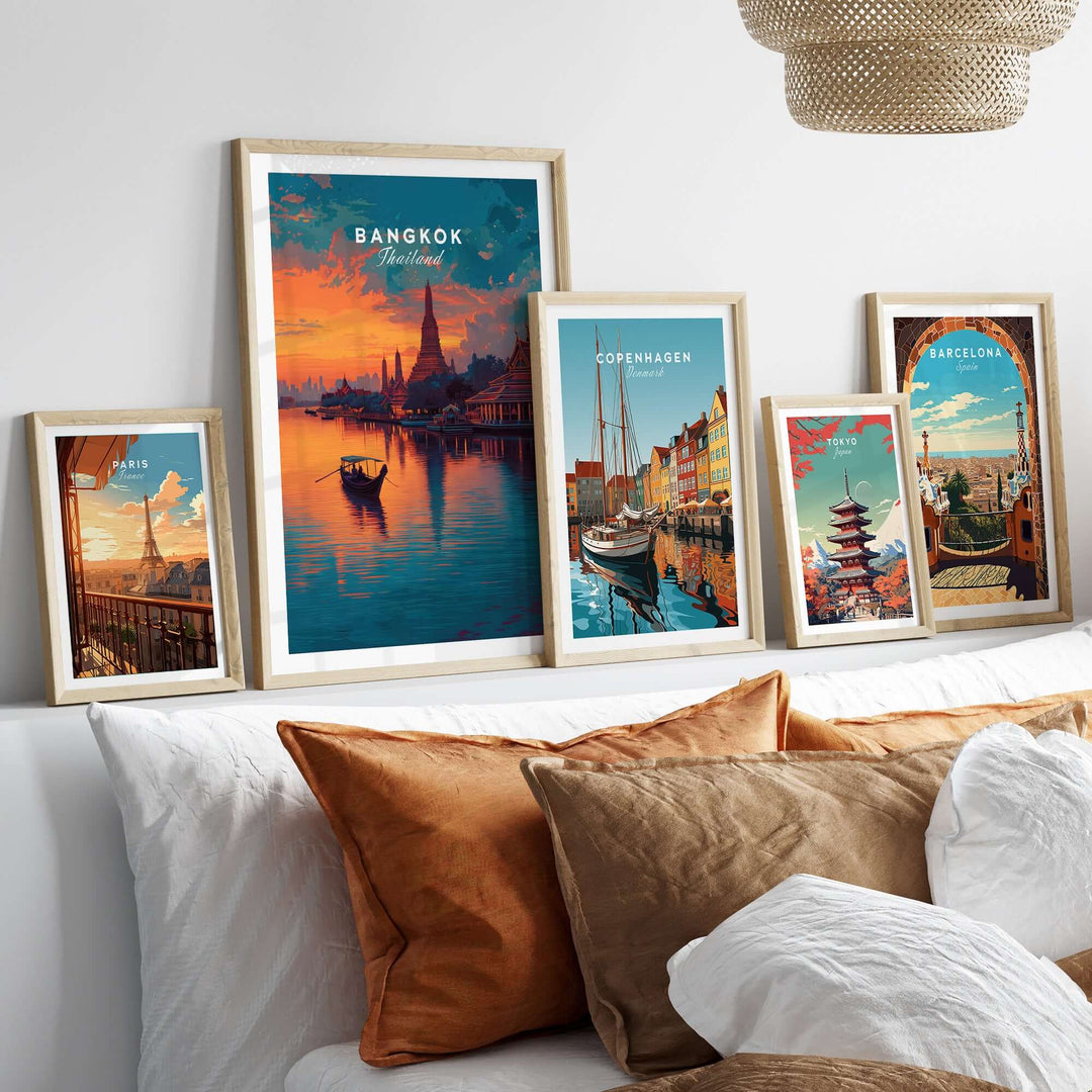 Framed prints of Bangkok, Copenhagen, and Barcelona on a stylish bed with decorative pillows.