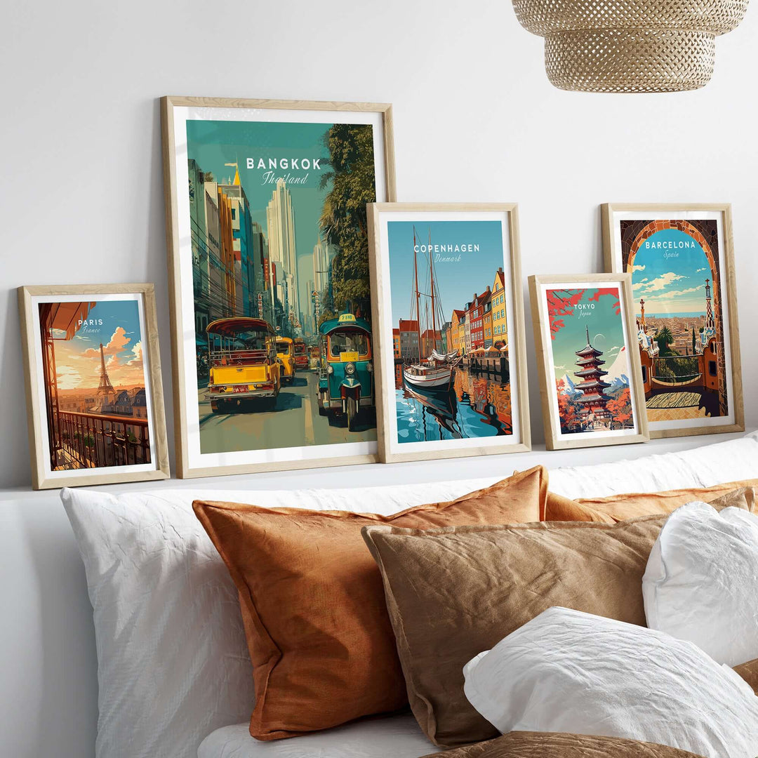 Bangkok Thailand poster featuring a vibrant tuk tuk street scene among framed travel prints on a cozy sofa.