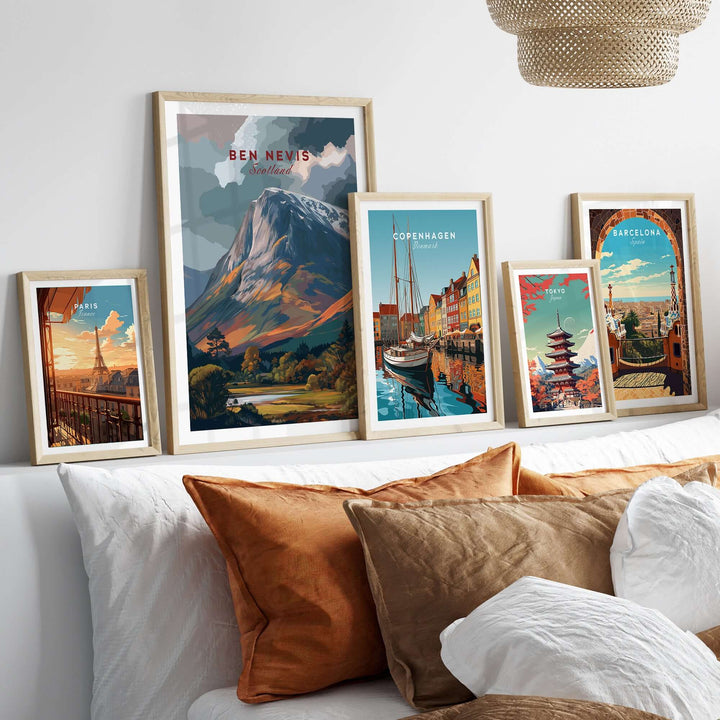 Ben Nevis snow-capped mountain poster among framed travel art on a cozy bed with decorative pillows.