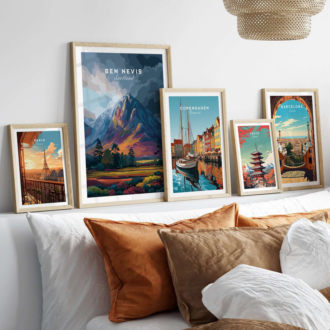 Framed Ben Nevis art print among colorful cityscape illustrations on a stylish bed display.