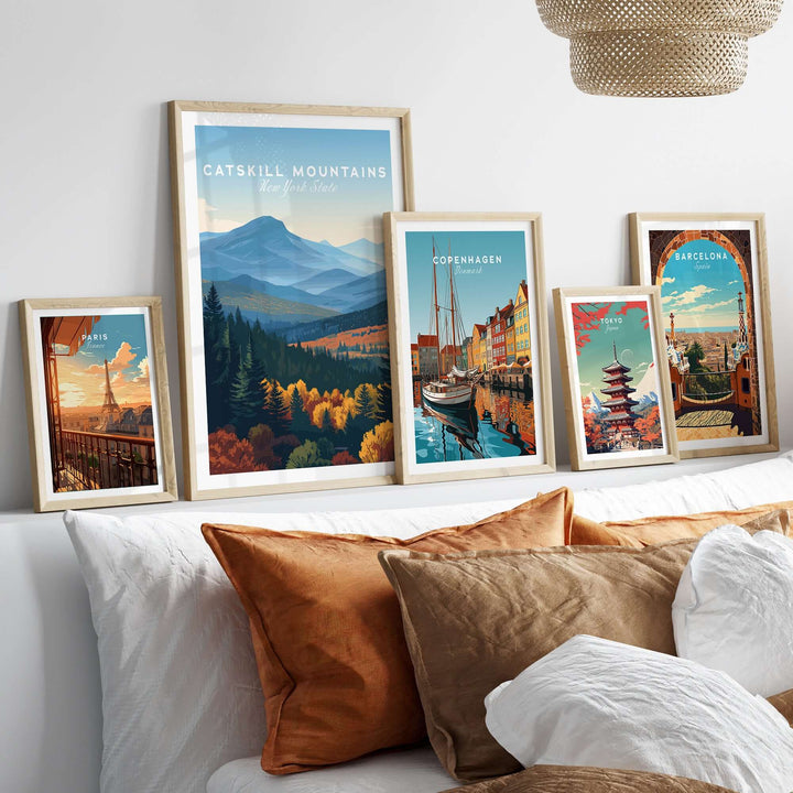Framed art prints showcasing Catskill Mountains and cityscapes on a stylish bed with cozy pillows.