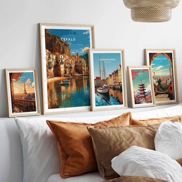 Gallery wall featuring Cefalù Italy poster and other city art prints in stylish frames above a cozy sofa.