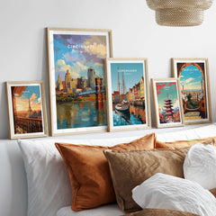 Cincinnati Ohio Skyline Print - Roebling Bridge Wall Art displayed among other city prints on a stylish sofa.