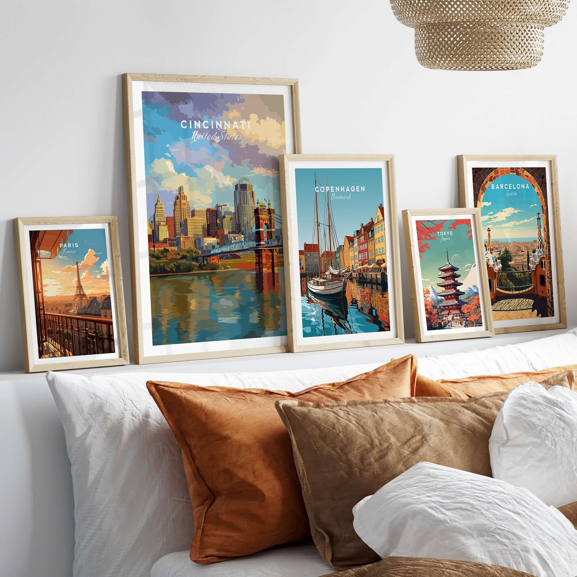 Cincinnati Ohio Skyline Print - Roebling Bridge Wall Art displayed among other city prints on a stylish sofa.