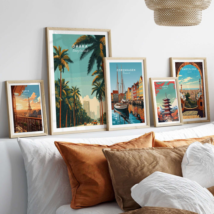 Colorful city life wall art prints of Dhaka, Copenhagen, and Barcelona displayed above a cozy sofa.