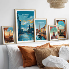 Glasgow City Street at Dusk Print - Scotland Wall Art displayed among other cityscape prints on a cozy sofa.