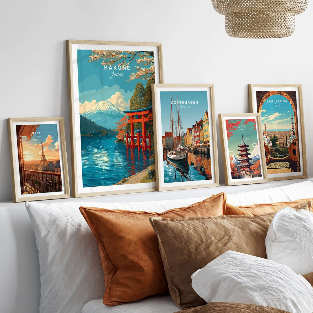 Framed artwork prints including Hakone, Copenhagen, and Barcelona on a stylish wall above a cozy sofa.
