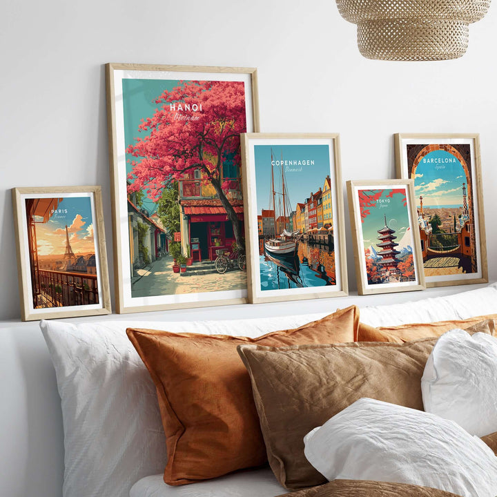 Colorful wall art prints featuring Hanoi cherry blossoms, Copenhagen harbor, and Barcelona architecture on a cozy couch.