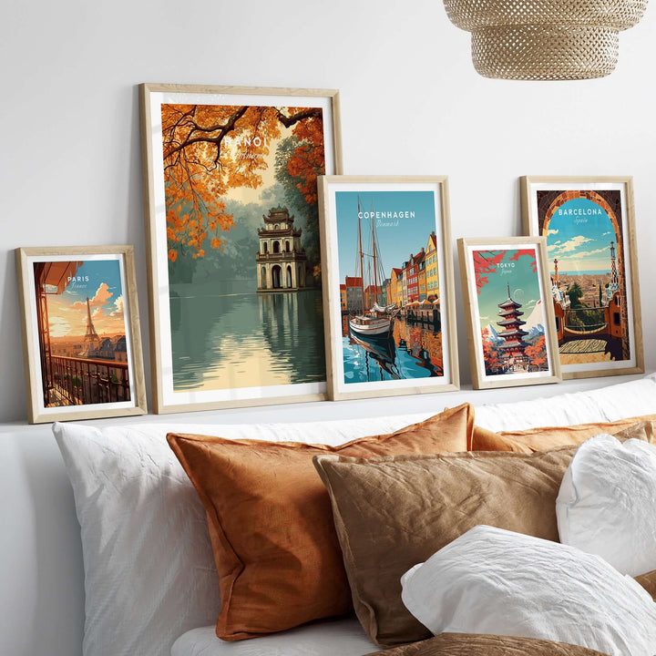 Framed posters of Hanoi's Hoan Kiem Lake, Copenhagen, Barcelona, and scenic landmarks displayed on a cozy couch.