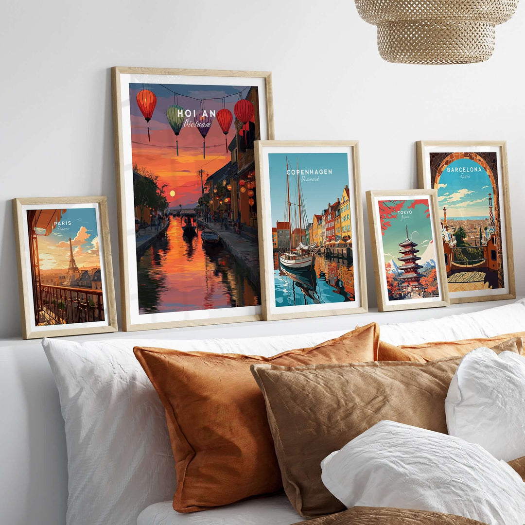 Framed Hoi An poster with sunset and lanterns, alongside other vibrant city prints on a cozy couch.