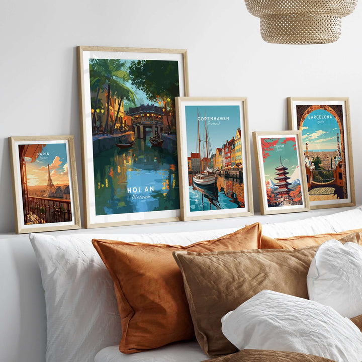 Gallery of travel posters featuring Hoi An, Copenhagen, Barcelona, displayed above a cozy bed with decorative pillows.