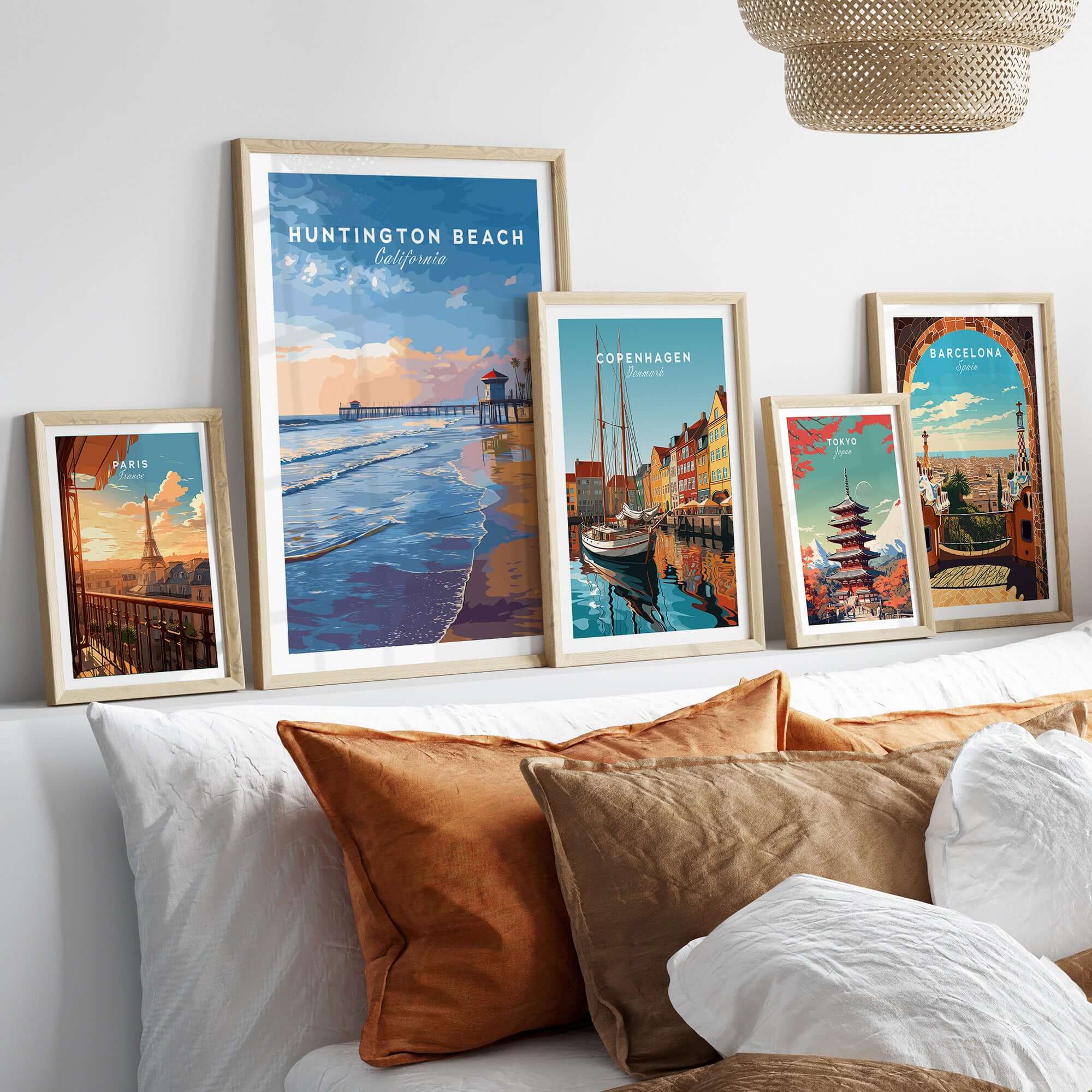 Huntington Beach Pier at Sunset Poster - Coastal California Wall Art displayed among framed city artwork on a cozy couch.