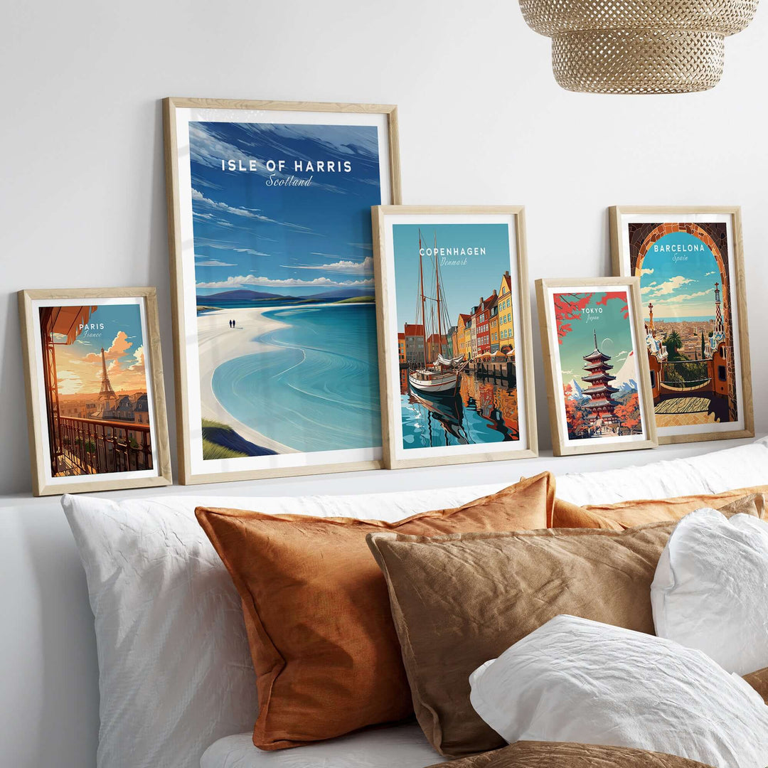Framed wall art prints of Isle of Harris, Copenhagen, and Barcelona on a cozy bed with decorative pillows.