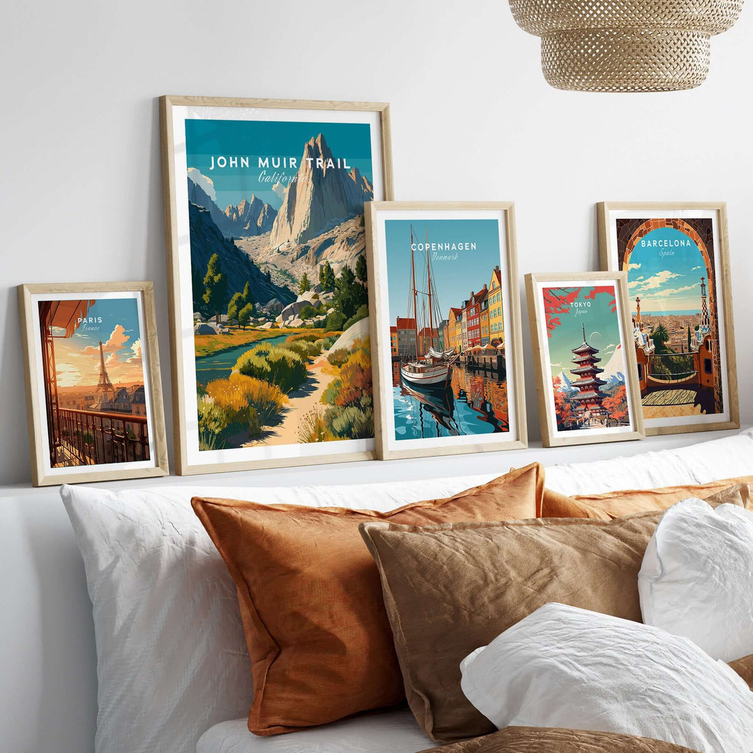 Framed prints of John Muir Trail and other cities, showcasing wilderness and travel art on a cozy bedroom wall.