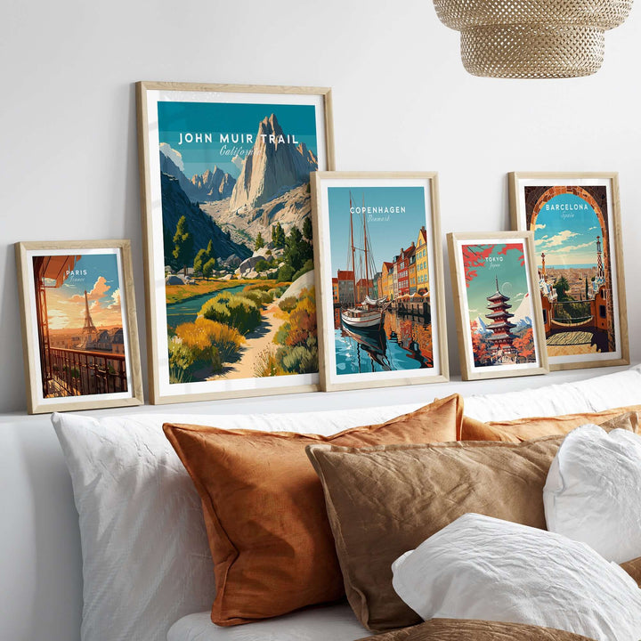 Framed prints of John Muir Trail and other cities, showcasing wilderness and travel art on a cozy bedroom wall.