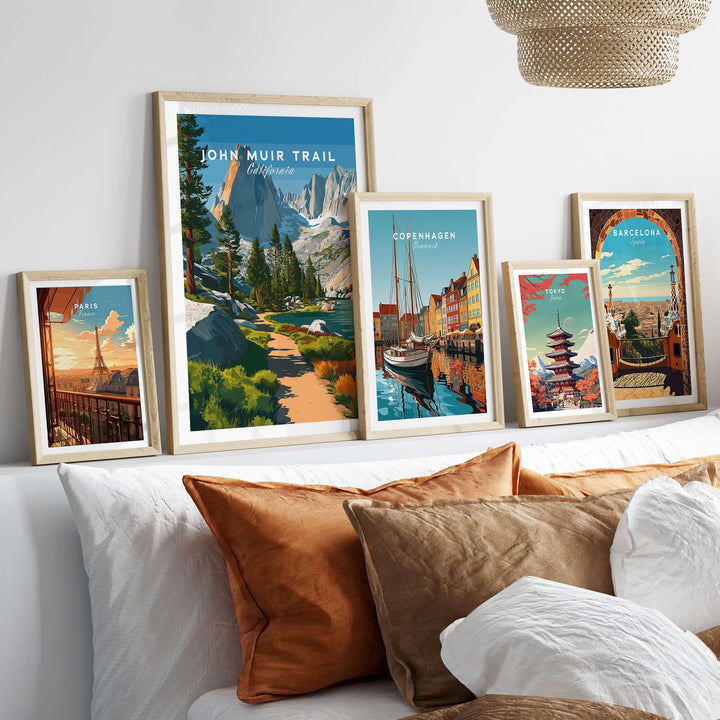 John Muir Trail poster and travel prints displayed on a cozy couch, showcasing scenic landscapes and vibrant city views.