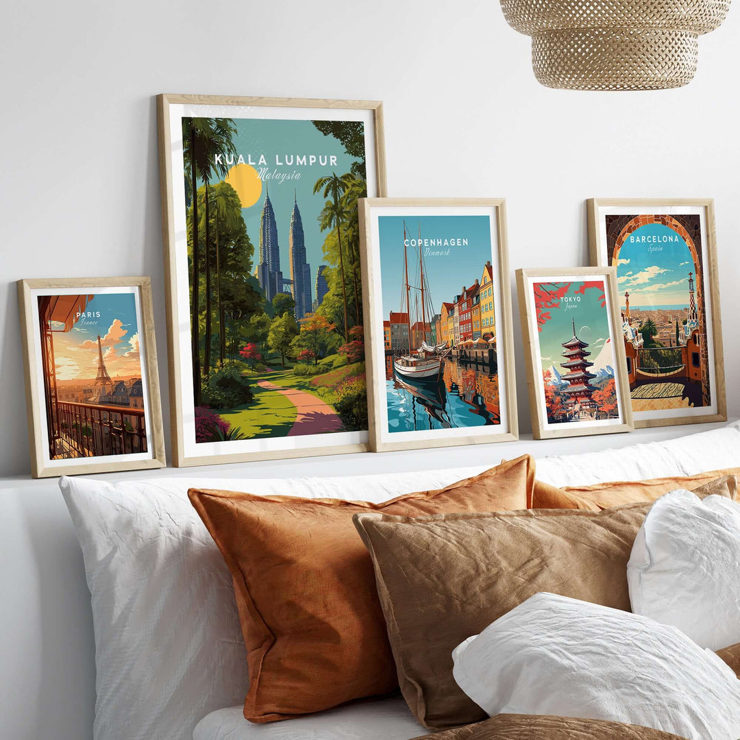Framed Kuala Lumpur poster with Petronas Towers among other city art on a stylish bed with cushions.