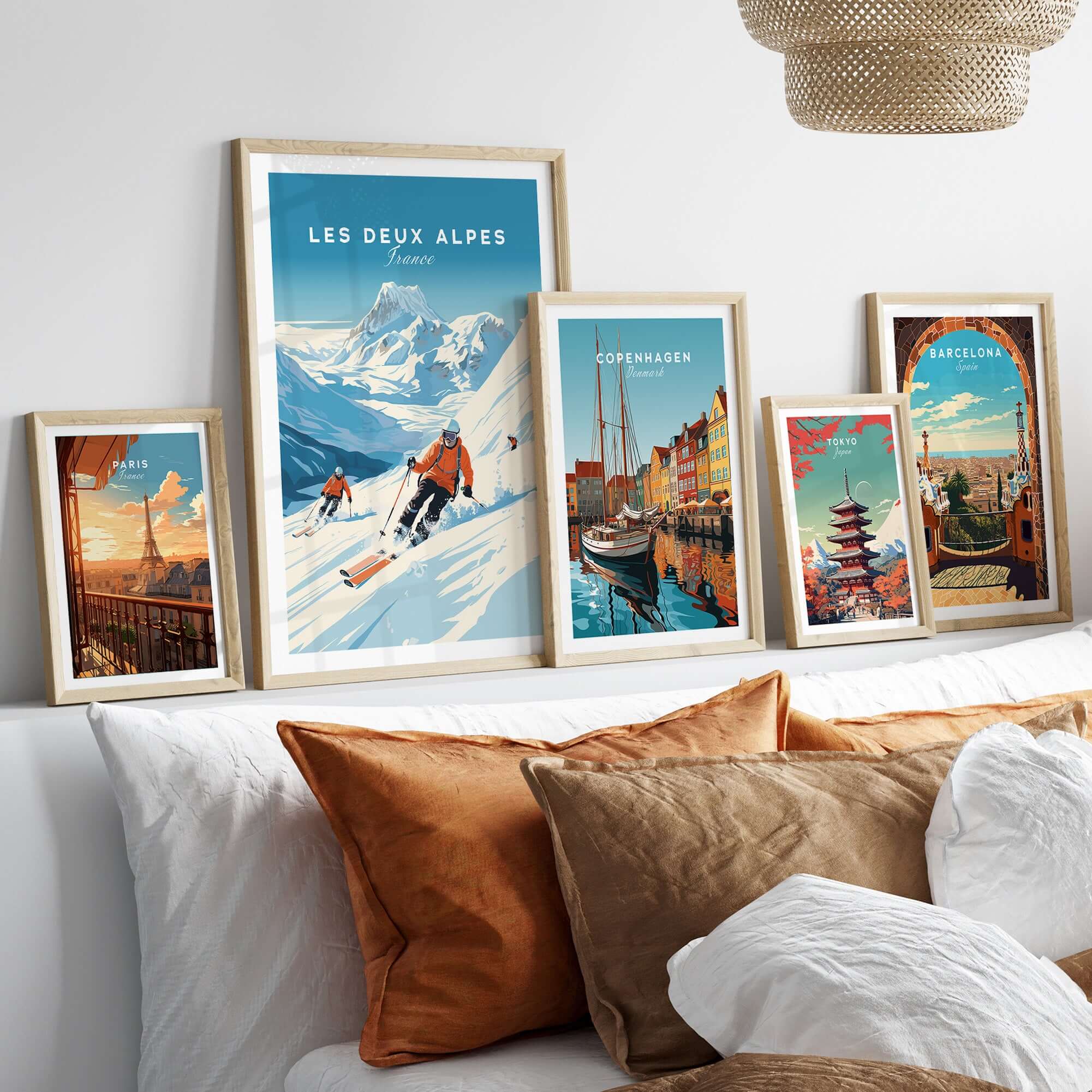 Les Deux Alpes travel poster displayed among framed city posters on a stylish home decor setup with cozy cushions.