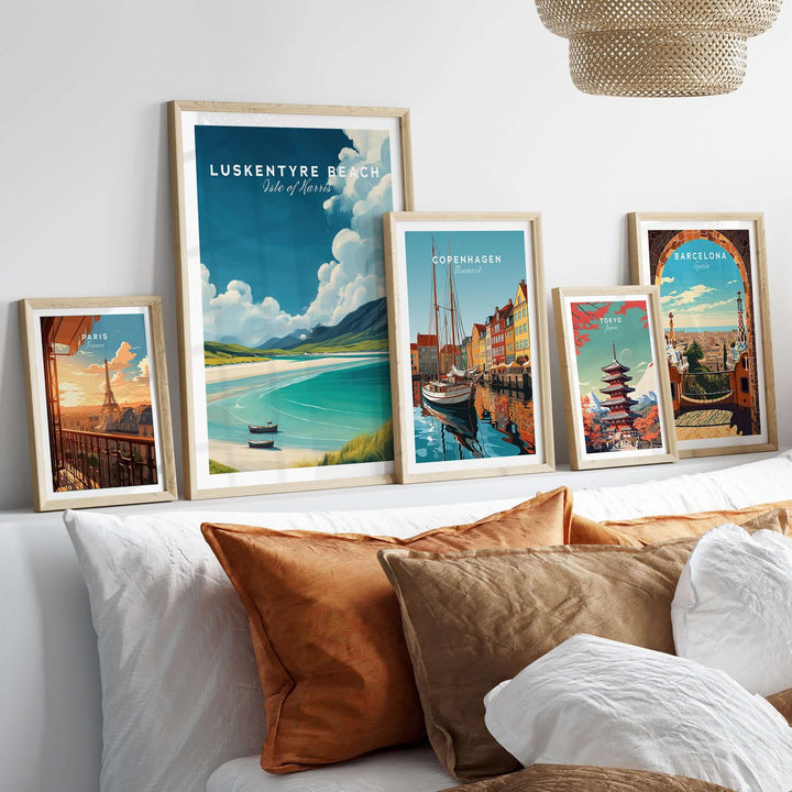 Framed Luskentyre Beach and city prints displayed on a stylish bed with decorative pillows.