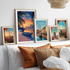 Maldives Travel Print - Sunset displayed among travel prints of various cities on a stylish sofa.
