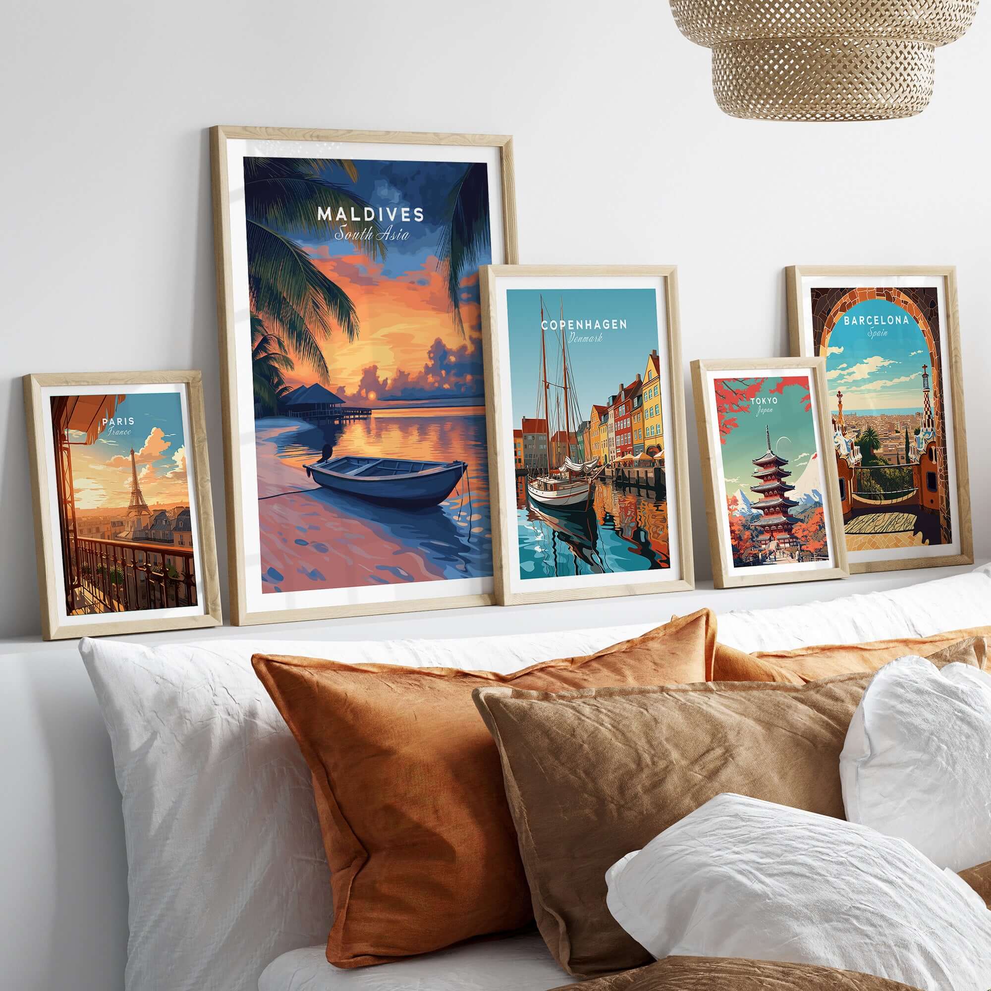 Maldives Travel Print - Sunset displayed among travel prints of various cities on a stylish sofa.