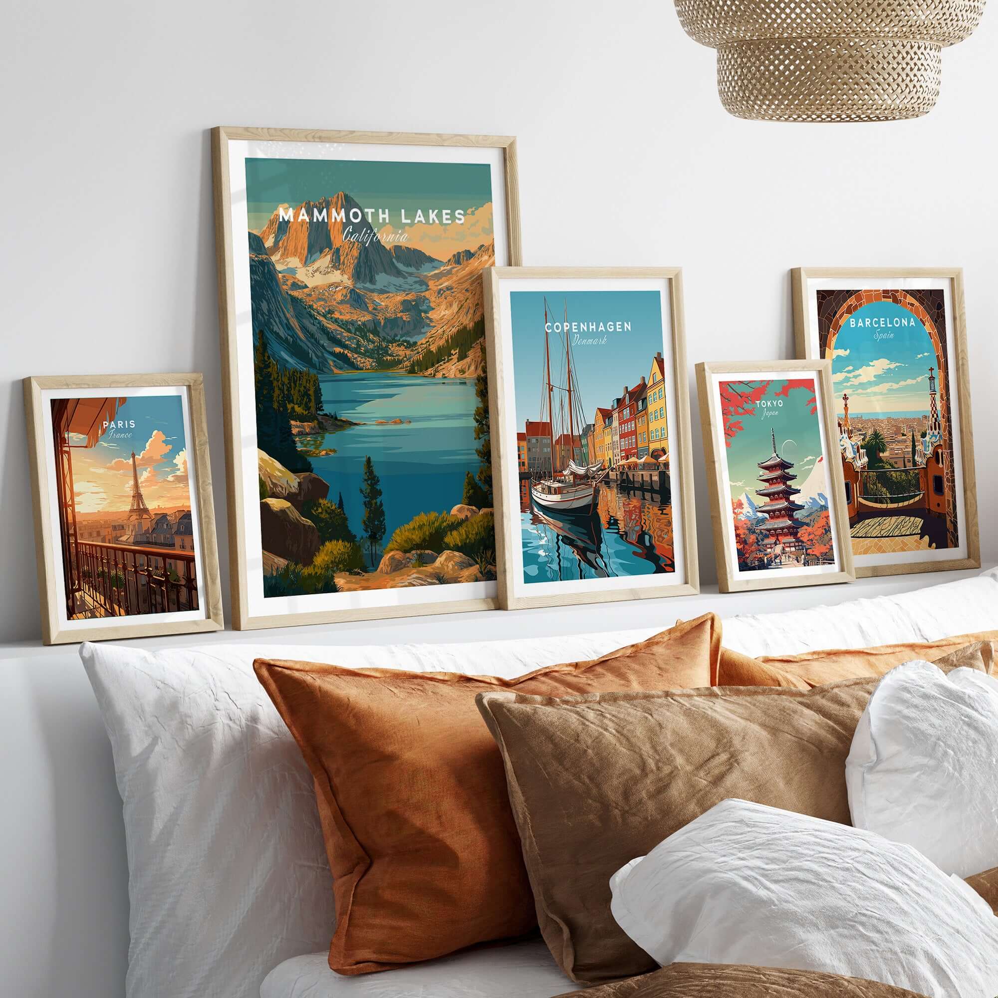 Mammoth Lakes Poster California - Rugged Mountain Wall Art showcased among other travel posters on a cozy sofa.