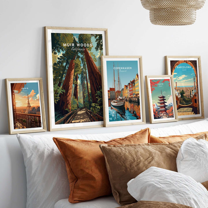 Framed prints of Muir Woods and various cities displayed on a stylish couch with decorative pillows.