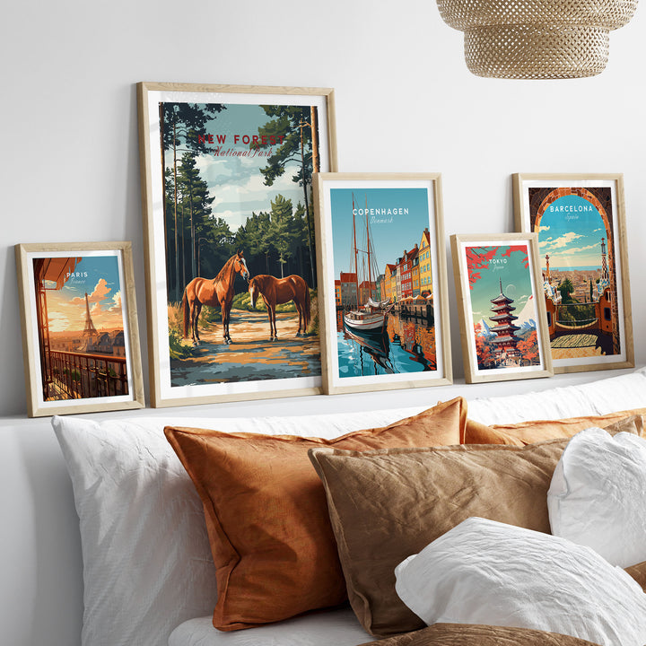 Collection of framed travel posters featuring landscapes, including New Forest National Park, displayed on a shelf above a sofa.