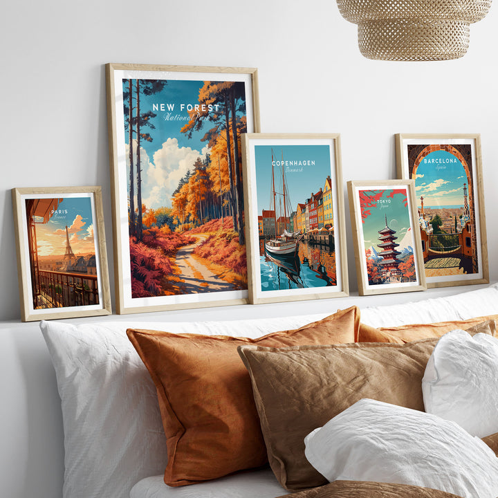 Vibrant collection of framed travel posters on a couch, featuring New Forest, Copenhagen, and Barcelona landscapes. Ideal wall art decor.