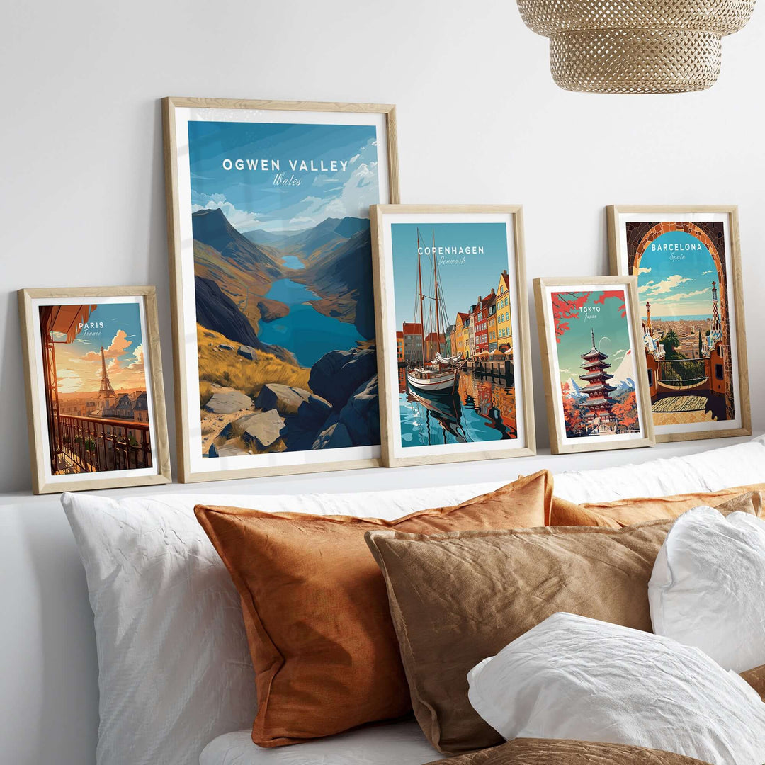 Ogwen Valley print along with other travel-themed wall art displayed on a cozy sofa in a modern living room.