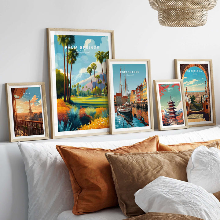 Elegant wall art collection featuring Palm Springs, Copenhagen, and Barcelona landscape prints on a stylish sofa.