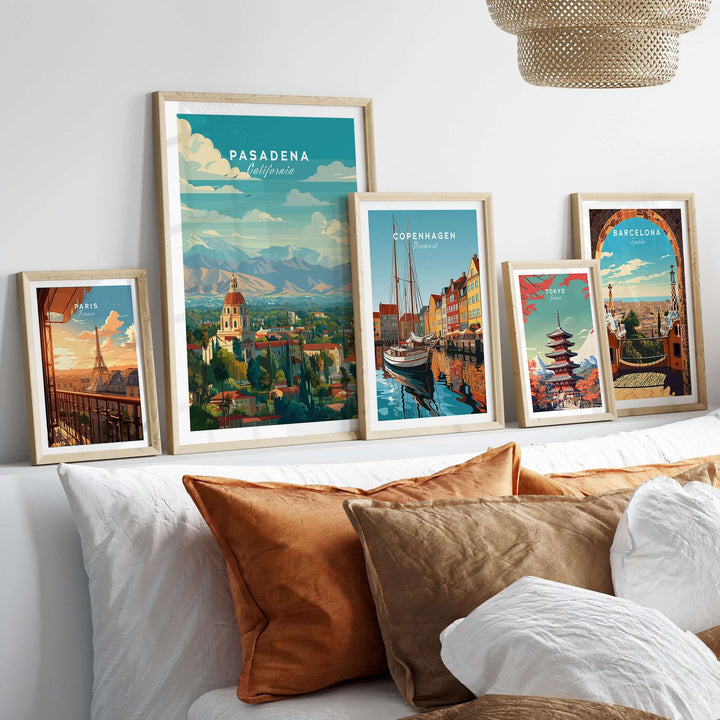 Framed travel prints featuring Pasadena, Copenhagen, and Barcelona with decorative pillows in a cozy setting.