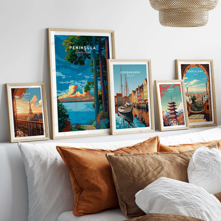 Framed travel posters including Peninsula State Park, Copenhagen, and Barcelona on a cozy couch.