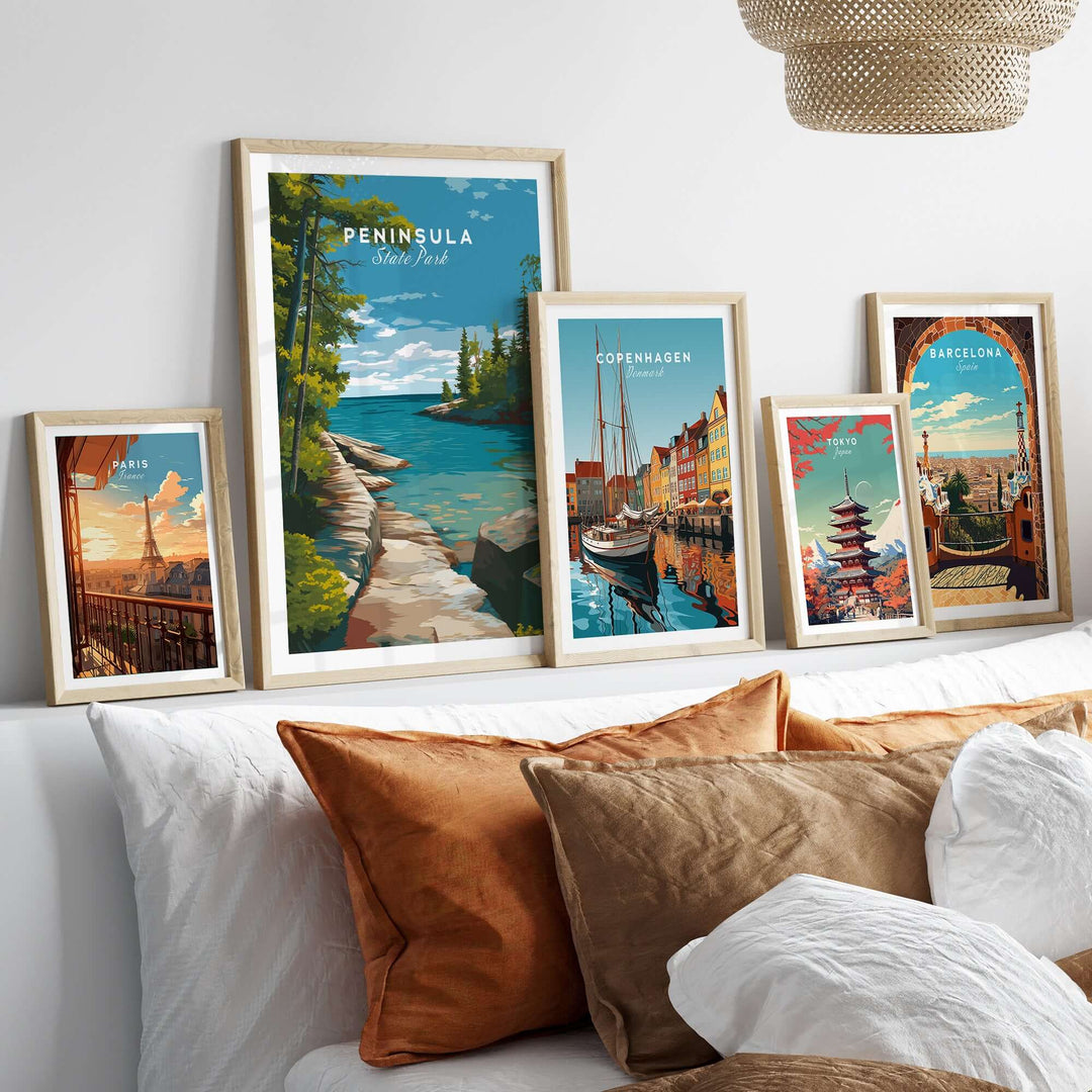Framed Peninsula State Park print among other scenic posters on a cozy bed with decorative pillows.