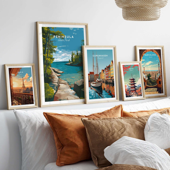 Framed Peninsula State Park print among other scenic posters on a cozy bed with decorative pillows.