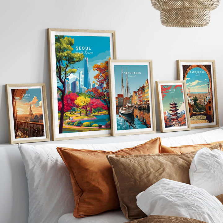 Framed prints showcasing Seoul, Copenhagen, and Barcelona cityscapes on a cozy sofa.