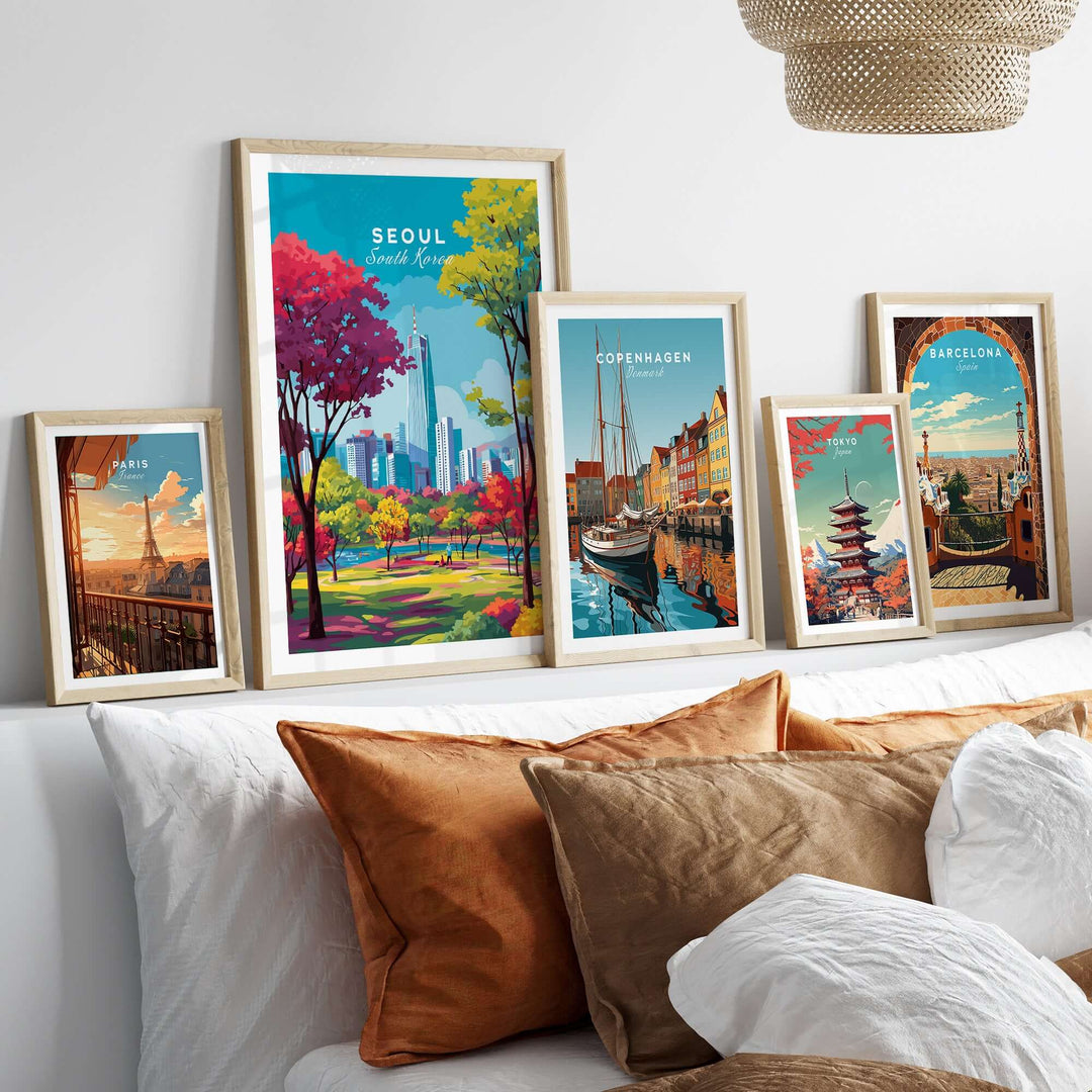 Stylish display of Seoul South Korea poster and framed cityscape prints on a shelf above cozy cushions.