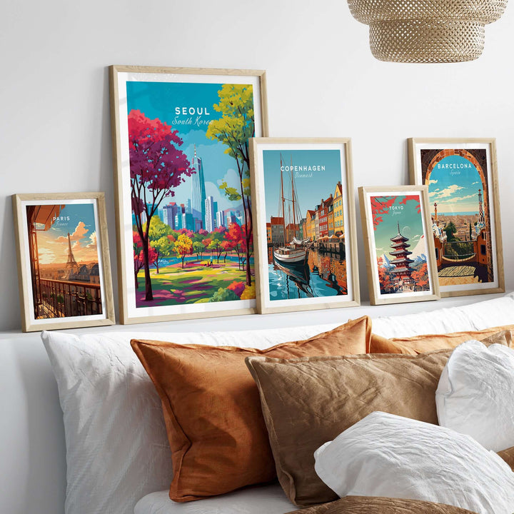 Stylish display of Seoul South Korea poster and framed cityscape prints on a shelf above cozy cushions.