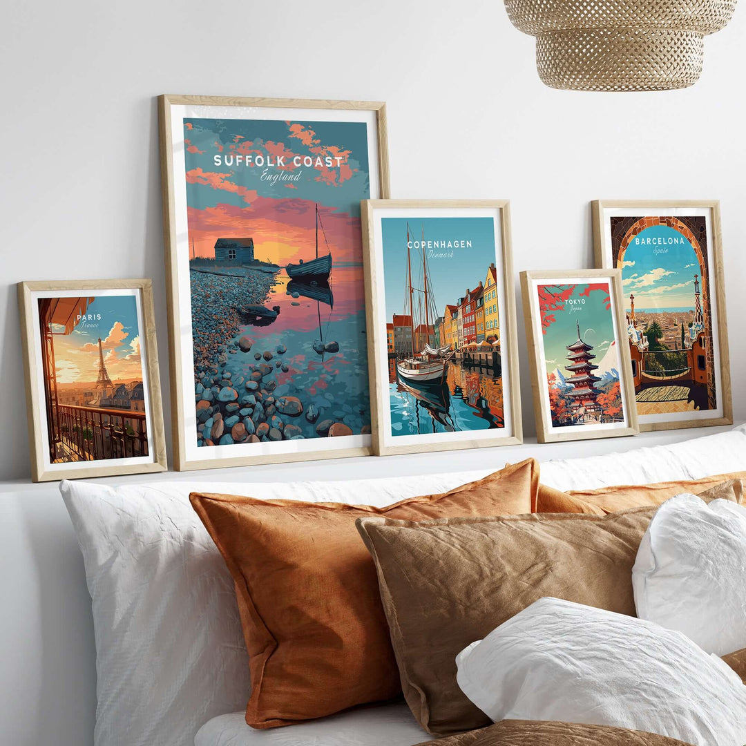 Suffolk Coast print and travel art displayed in frames on a cozy sofa with decorative pillows.