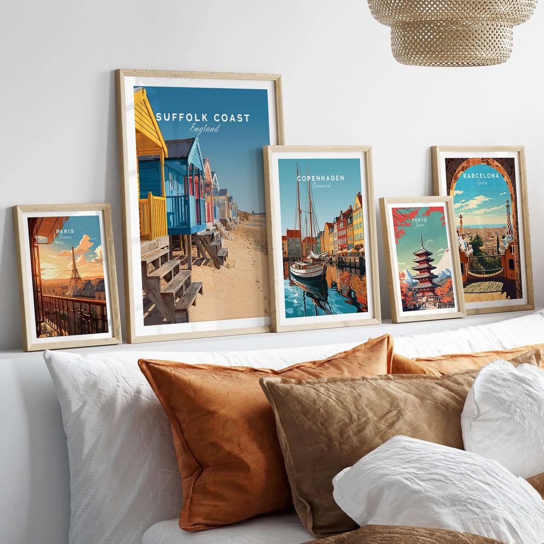Framed prints of Suffolk Coast beach huts and other cityscapes displayed over a cozy sofa.