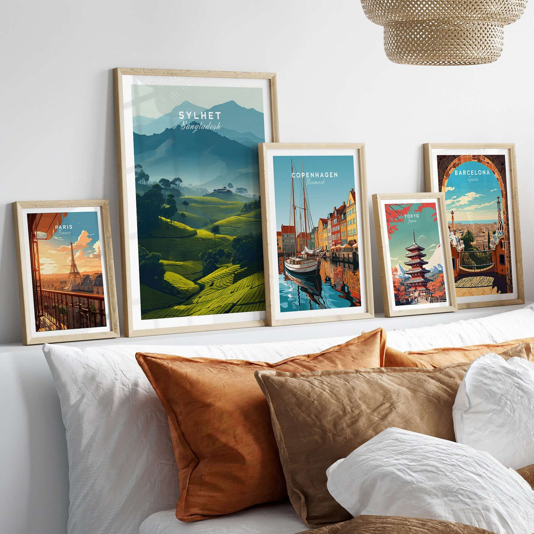 Stylish display of travel posters featuring Sylhet tea plantations and cityscapes of Copenhagen and Barcelona.