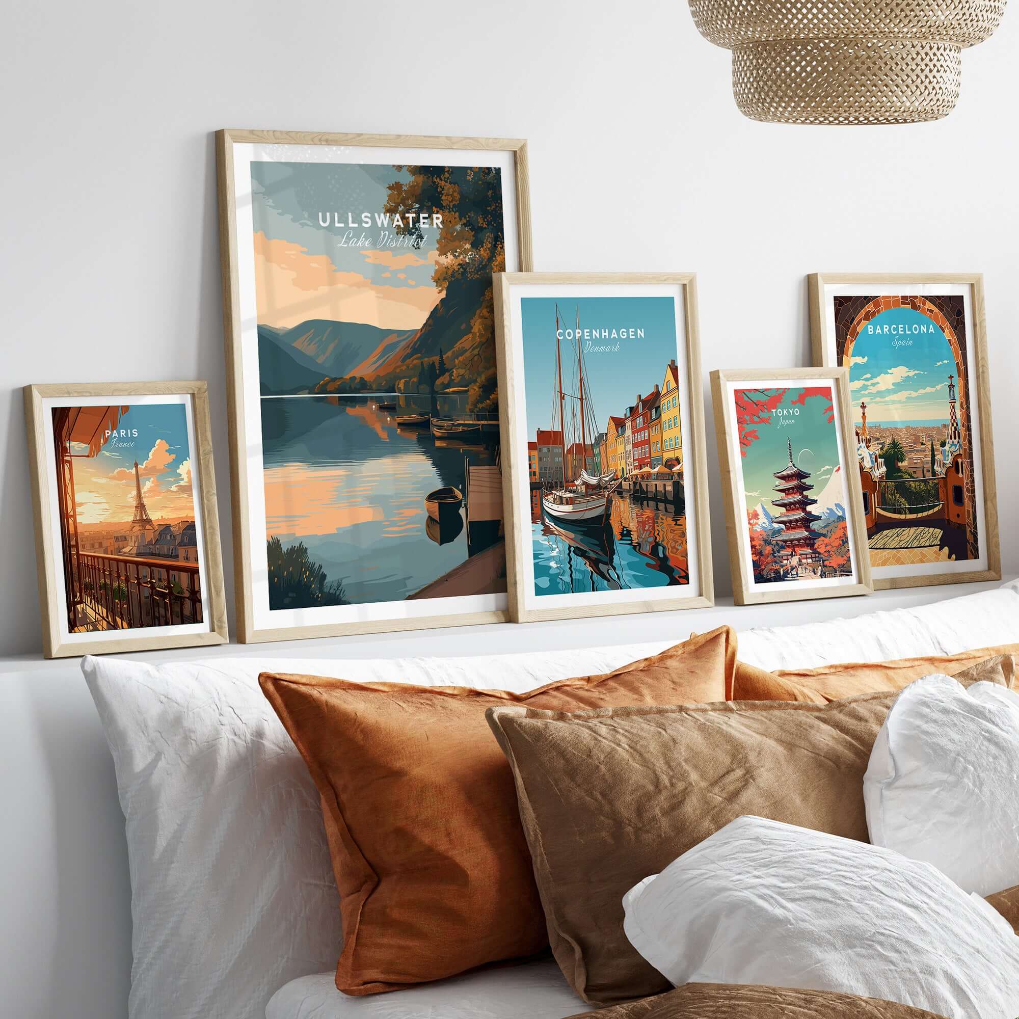 Ullswater Lake District Lakeside Boats Poster - Tranquil Dock Scene Print among framed travel posters on a cozy sofa.