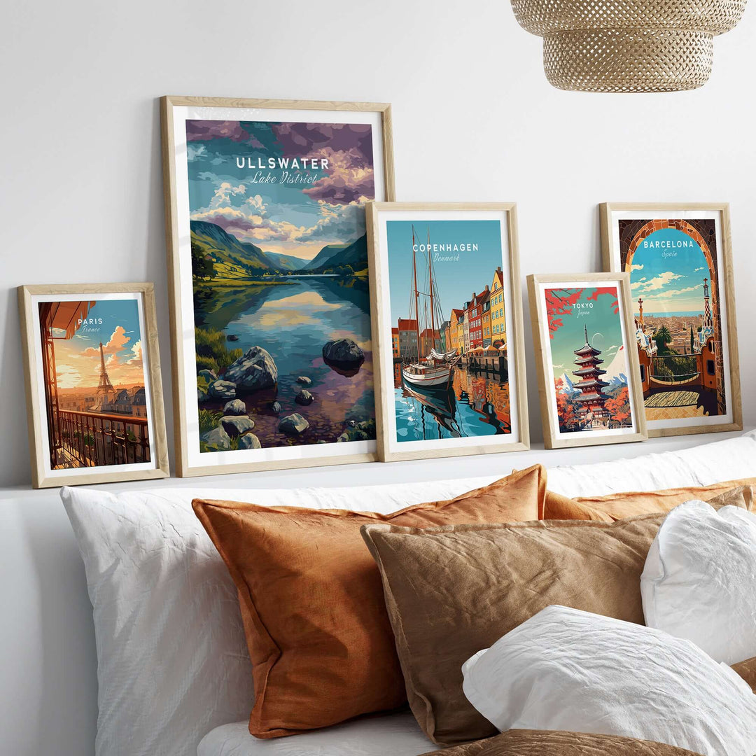 Ullswater Lake District mountain view print among framed travel art on a cozy bed with textured pillows.