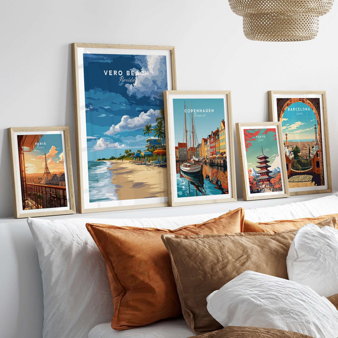 Gallery of travel-themed artwork including Vero Beach, Copenhagen, and Barcelona prints displayed above a cozy sofa.