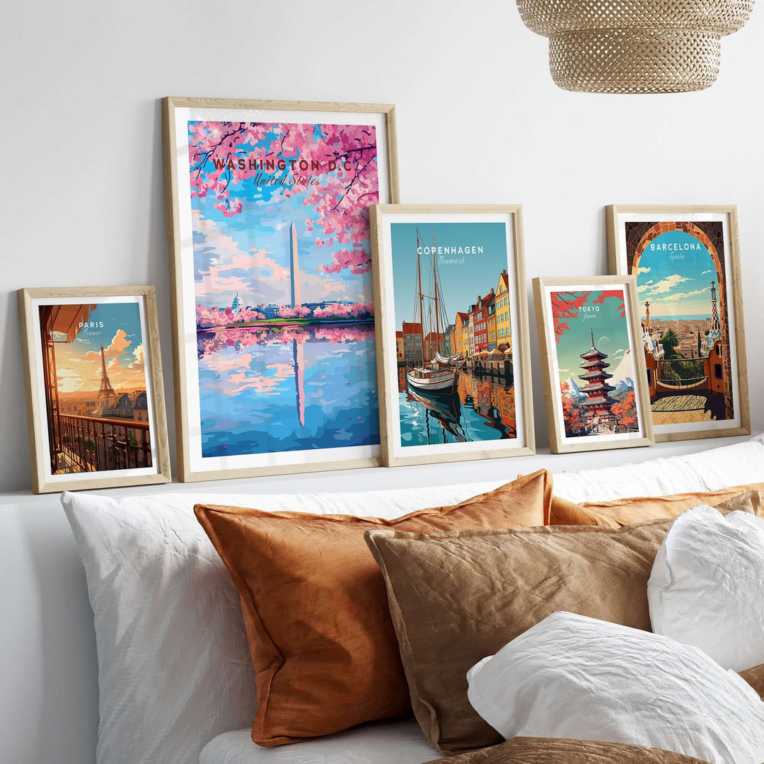 Art display of city posters including Washington D.C. Cherry Blossom, Copenhagen, and Barcelona on a modern bed.