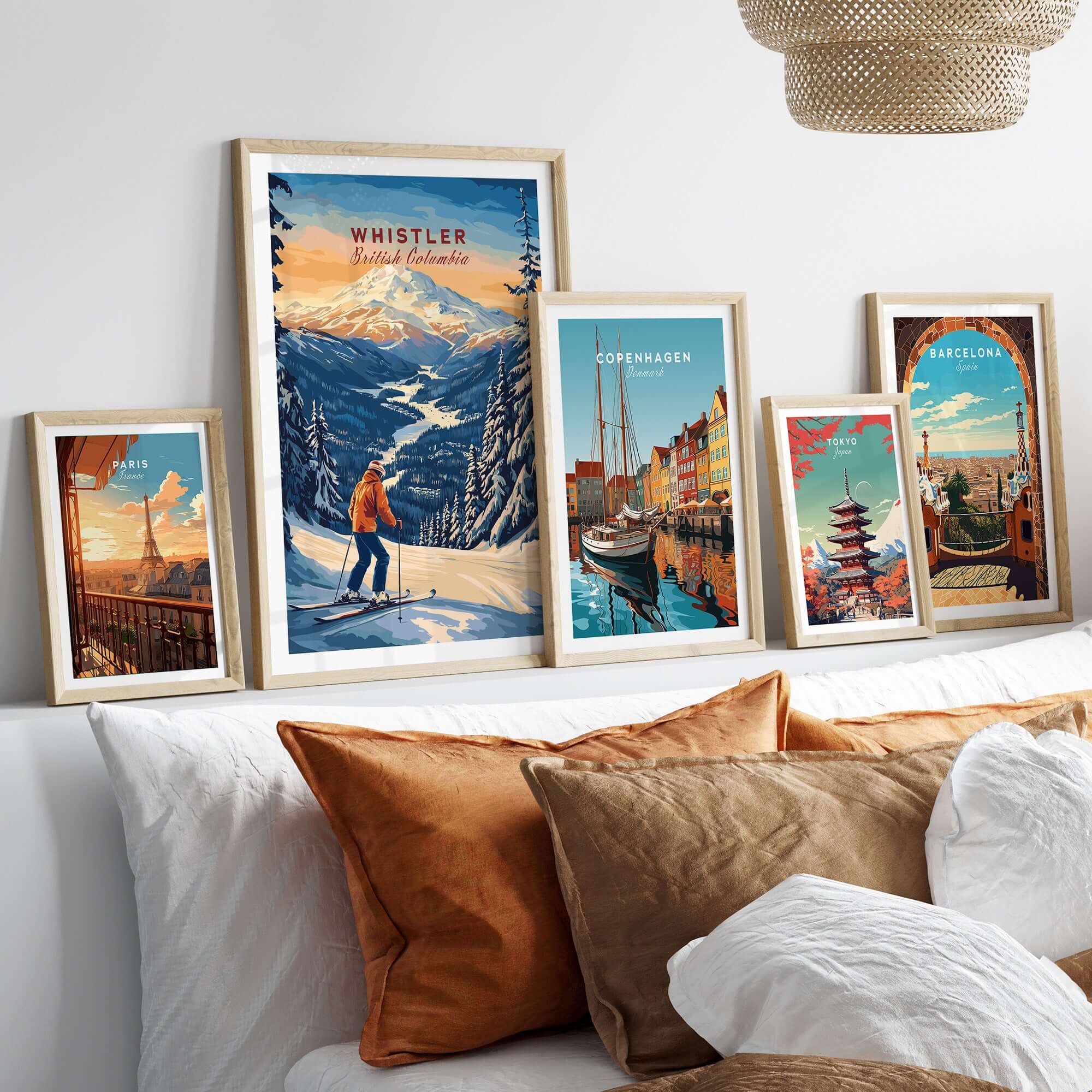 Whistler Travel Poster and other city posters displayed above a cozy couch with decorative pillows.